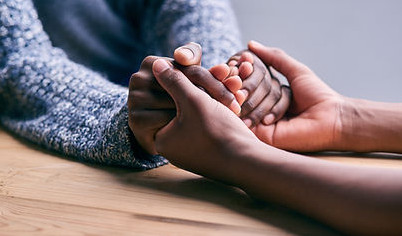 Two people hold hands.